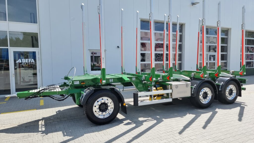 Holztransport Anhänger mit Rungen für Rundholz vor Werkhalle von BEFA Fahrzeugbau
